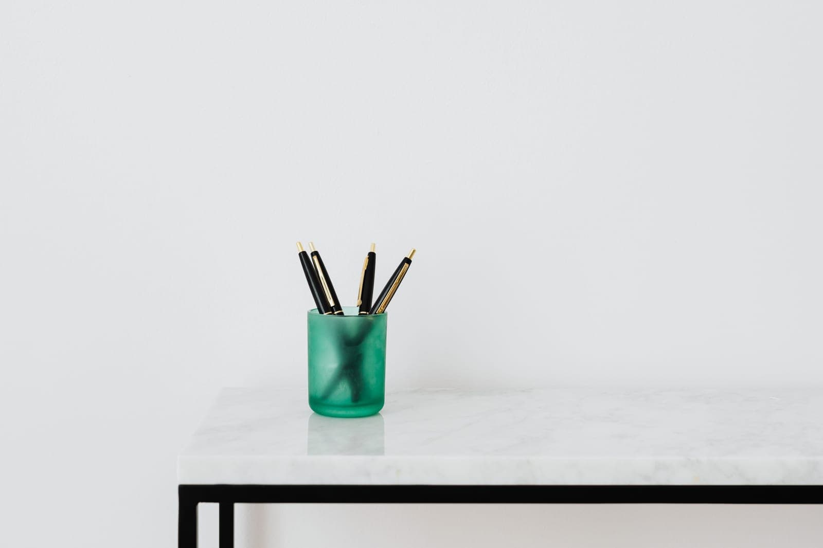 A desk organizer holding pens and pencils on a tidy workspace