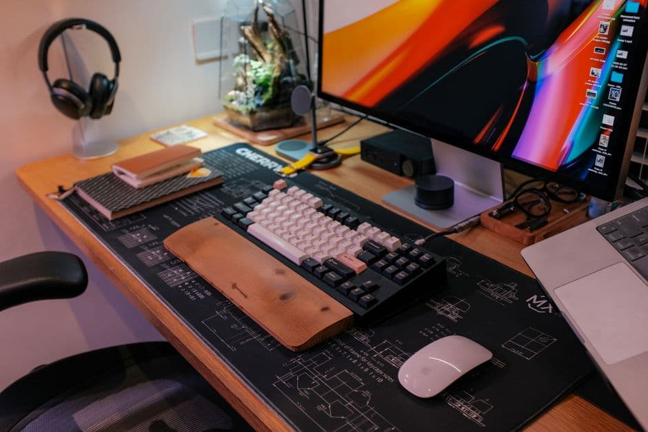 A tidy workspace with a keyboard, monitor and desk accessories arranged neatly