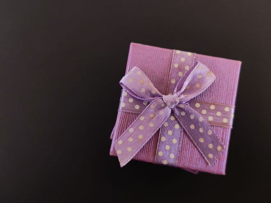 A purple gift box tied with a polka dot ribbon
