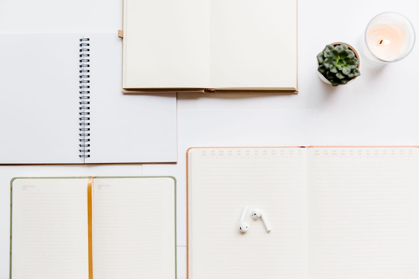 A planner and a blank notebook side by side on a desk