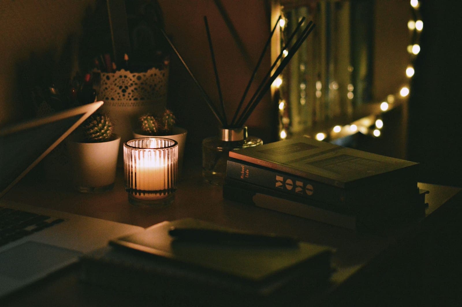 A student desk with open notebooks and a laptop in warm light