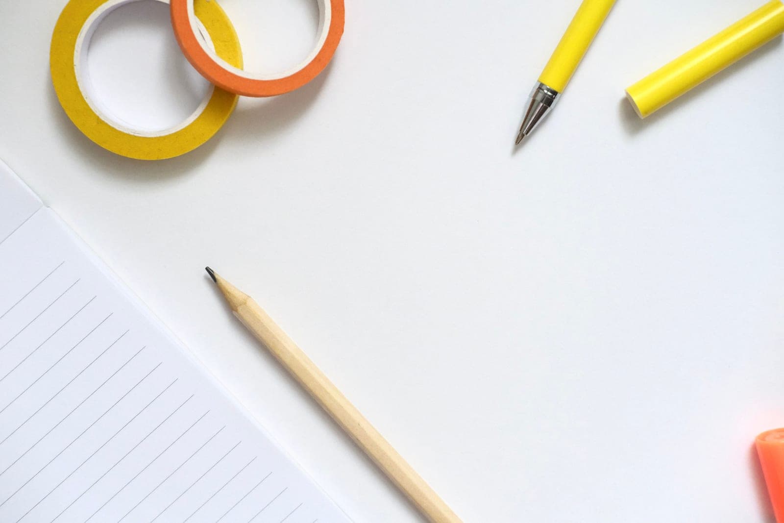 Pens, pencils and small notebooks arranged on a table