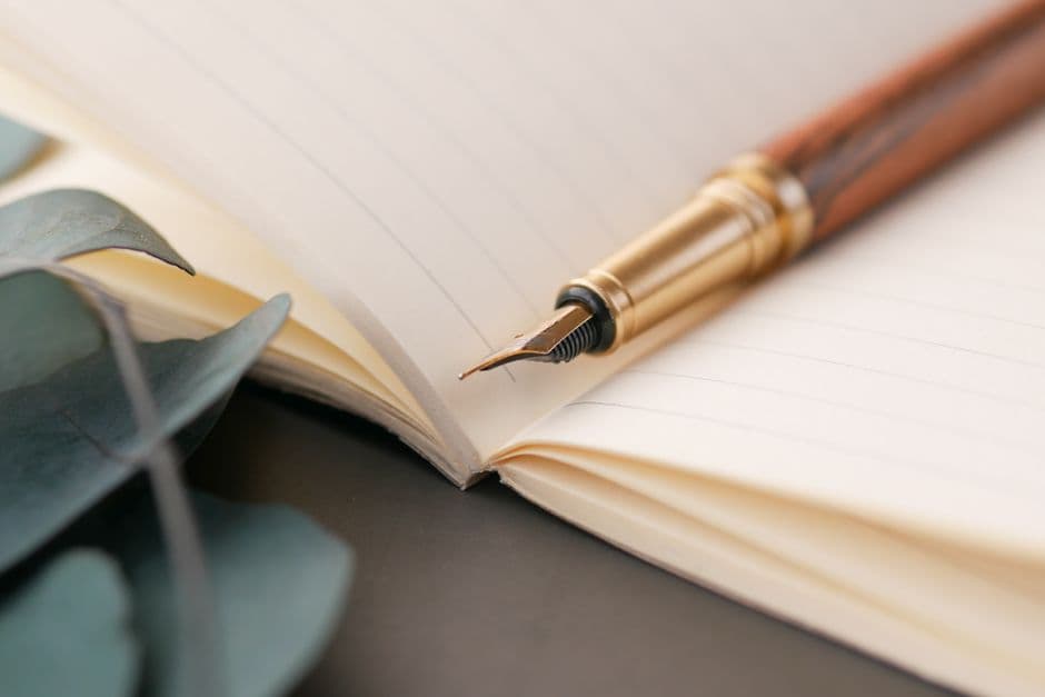 A fountain pen resting on the open page of a lined notebook