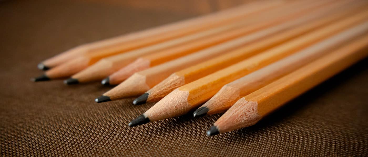 Sharpened wooden pencils arranged on a textured surface