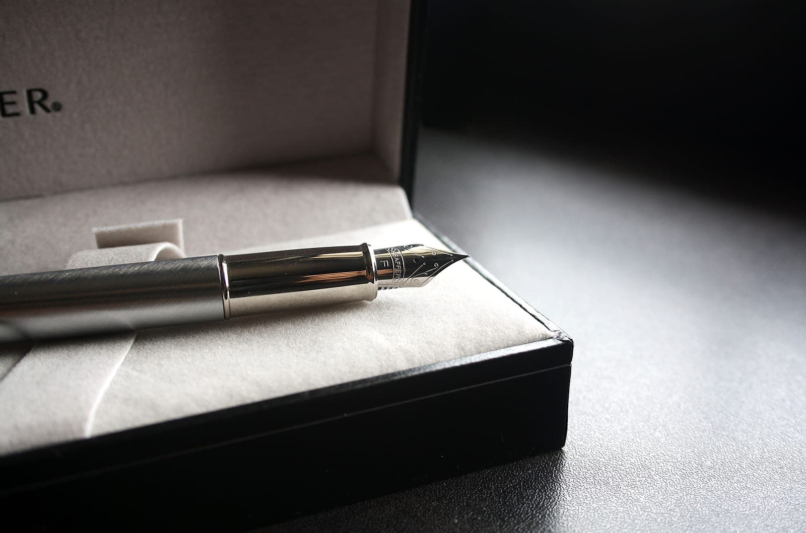 A fountain pen resting in an open presentation gift box