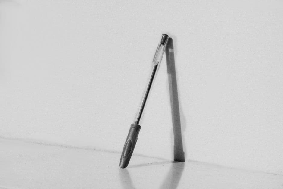 A gel ink pen casting a shadow on a white surface