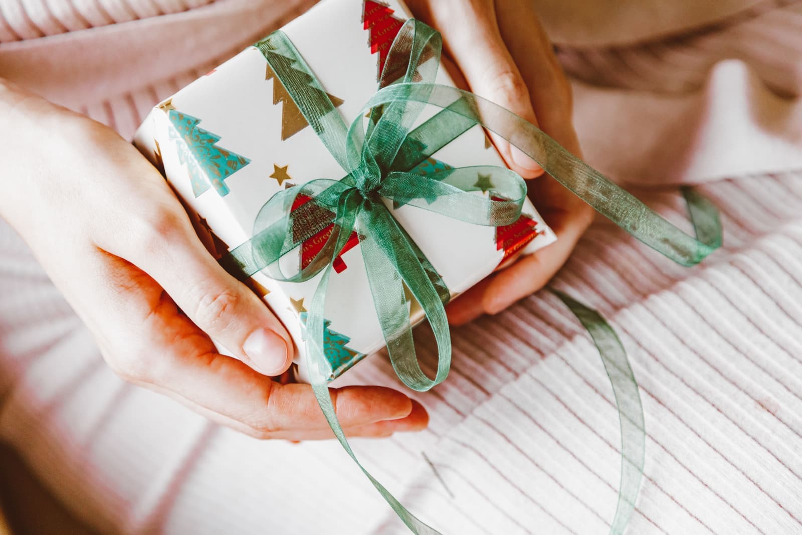A hand offering a wrapped pen gift box