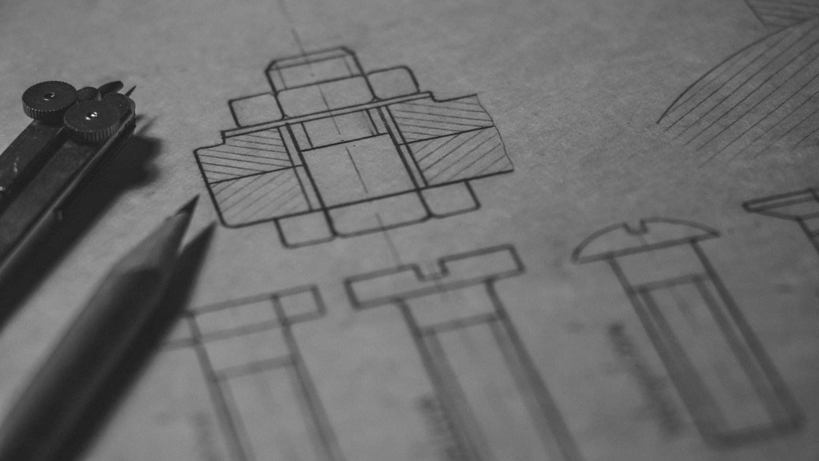 A mechanical pencil resting on technical drawing paper