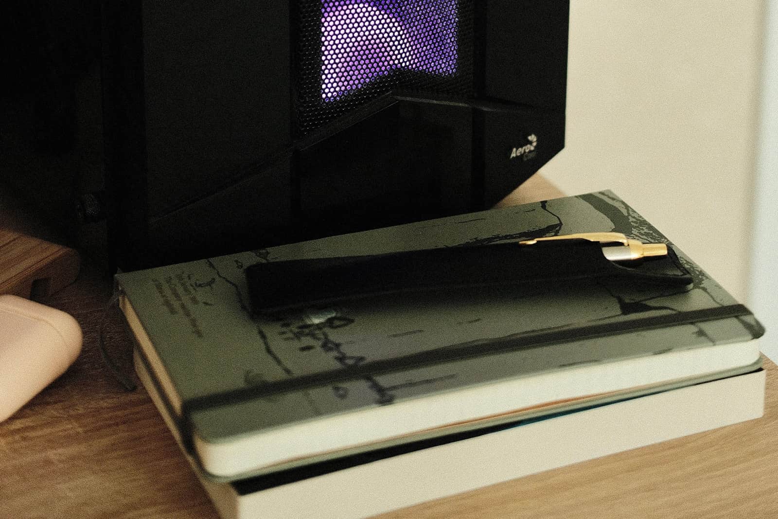 An elegant pen resting on a notebook in warm light