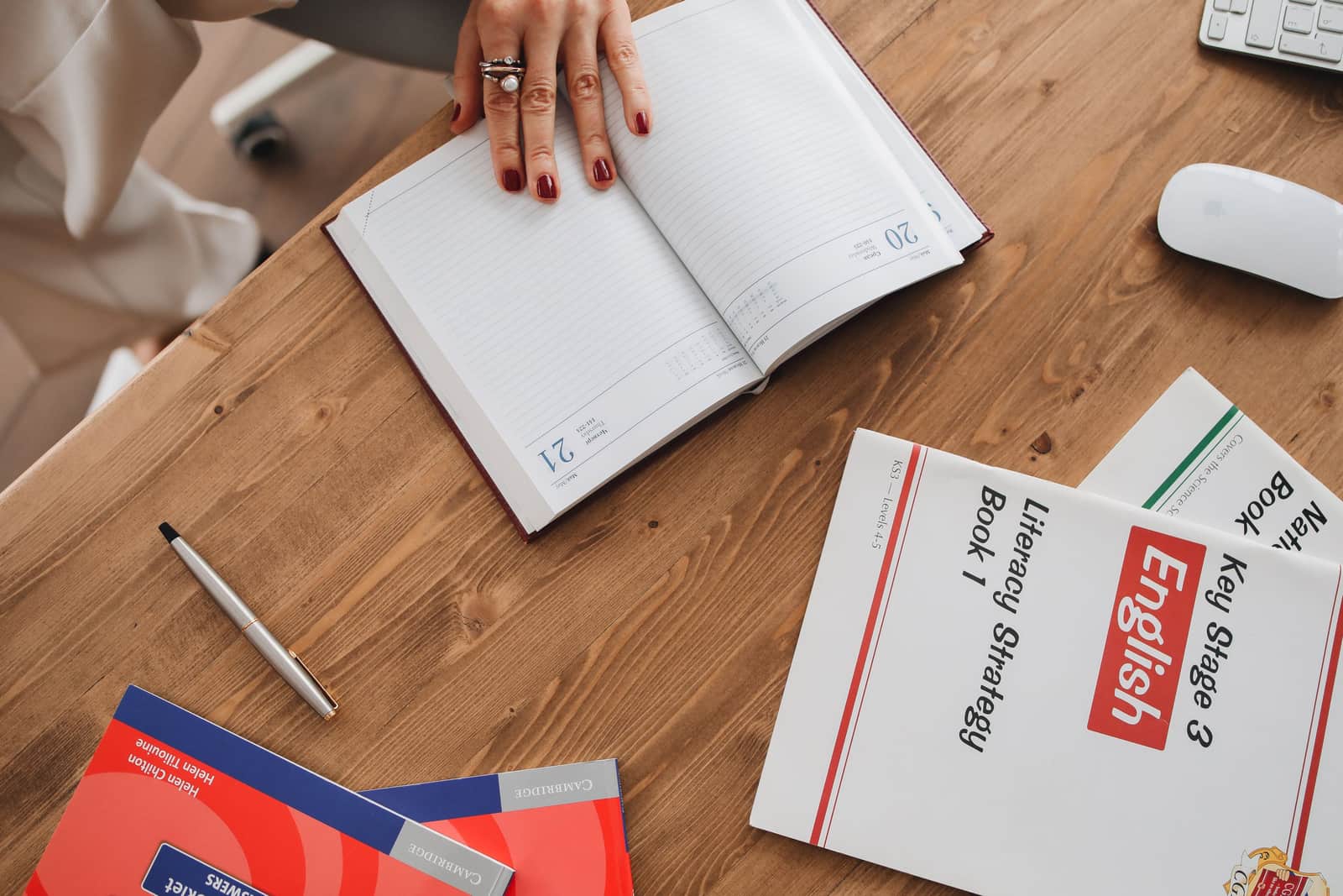 A teacher's lesson planner open on a desk with classroom supplies